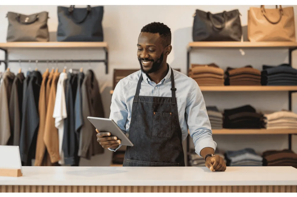 African SME retail business owner reviewing store metrics on a tablet
